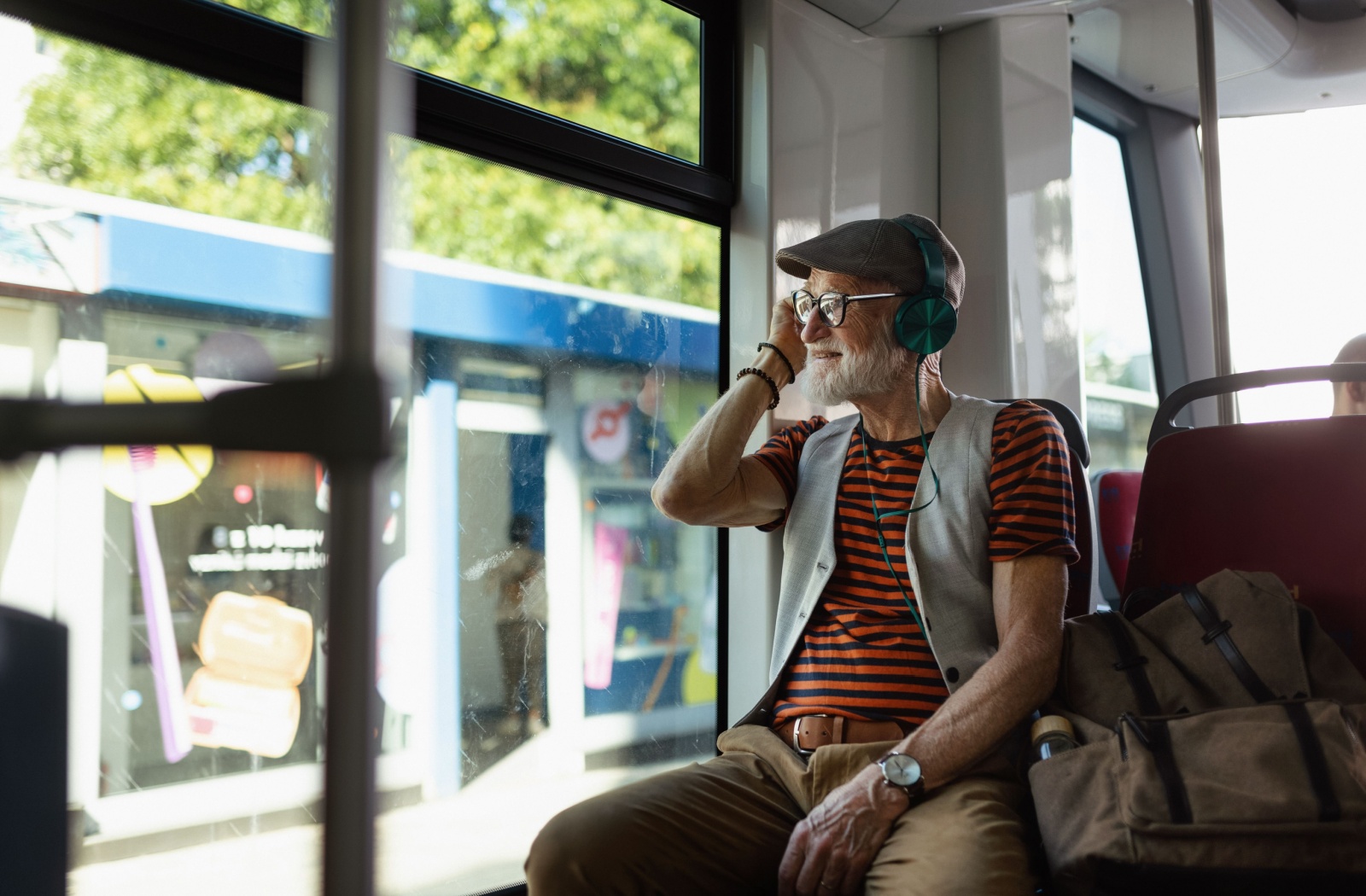 A happy senior listens to music in the headphones as they use public transportation to tour Nashville.