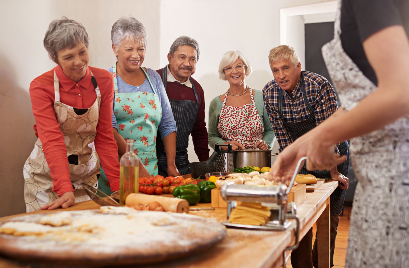 A group of older adults participate in a cooking class together.