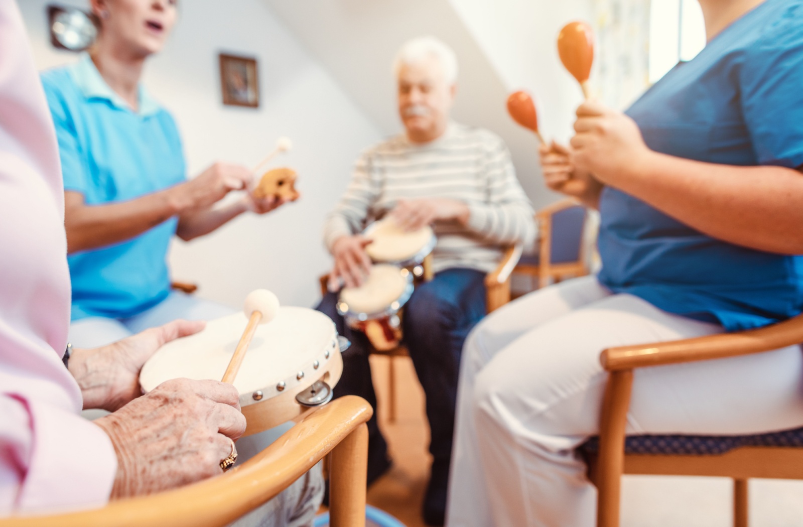 A group of senior residents participate in a music therapy program at a senior living community.